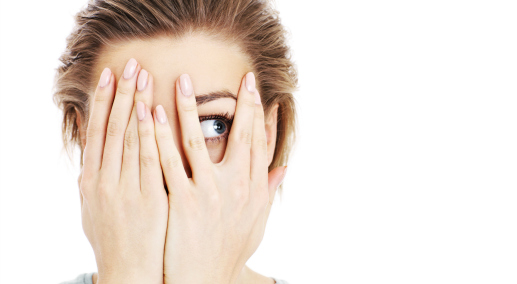 A picture of a scared woman covering her eyes over white background