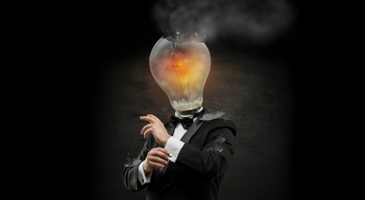 Businessman with exploded overworked lamp head on black background.