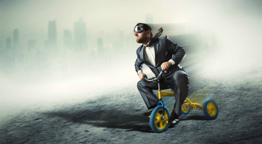 Odd businessman riding a small bicycle against dark city
