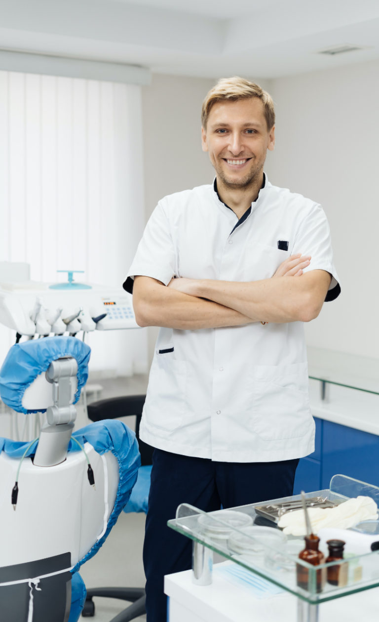 portraitpositiveyoungmaledentistuniformwithcrossedhandsdental